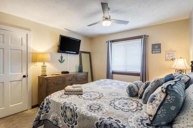 bedroom featuring ceiling fan, light colored carpet, and a textured ceiling