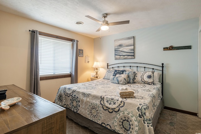 bedroom with ceiling fan and a textured ceiling