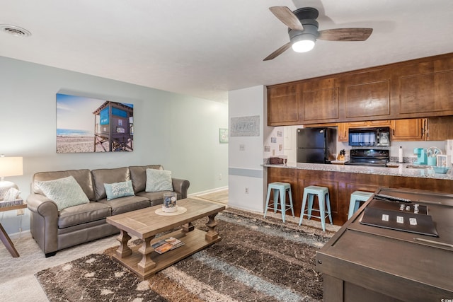 carpeted living room featuring ceiling fan