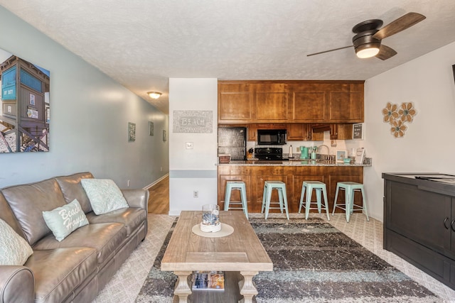 living room featuring a textured ceiling and ceiling fan