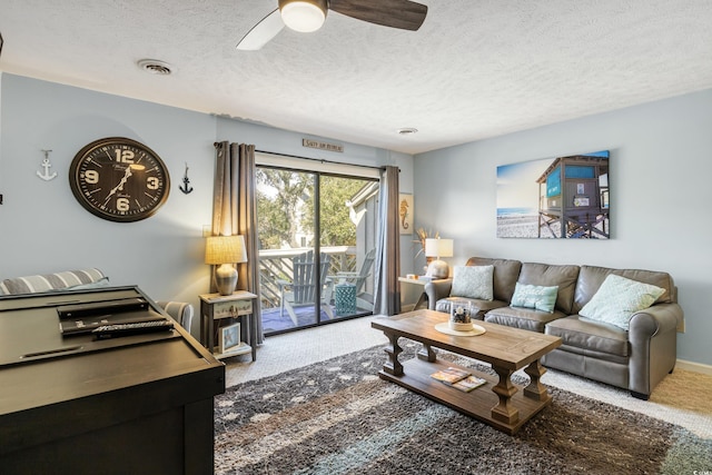 living room featuring carpet flooring, a textured ceiling, and ceiling fan