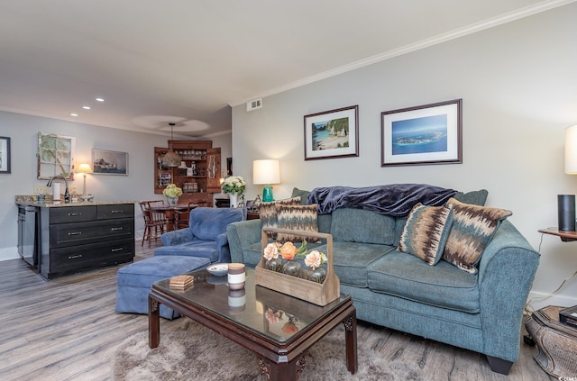 living room with light hardwood / wood-style floors and ornamental molding