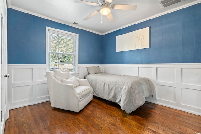 bedroom with dark hardwood / wood-style flooring, ornamental molding, and ceiling fan