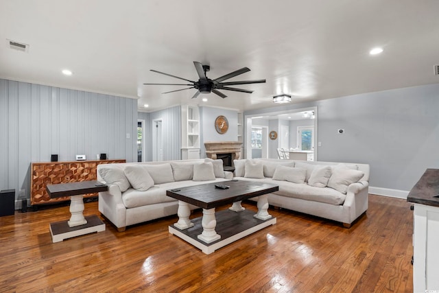 living room featuring ceiling fan, wood-type flooring, and ornamental molding