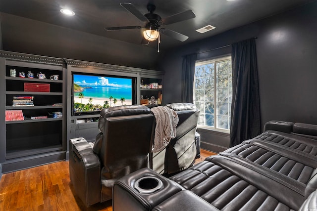 home theater with dark wood-type flooring and ceiling fan