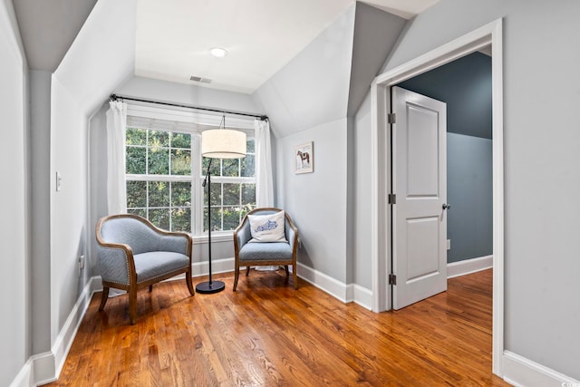 sitting room with hardwood / wood-style flooring and vaulted ceiling