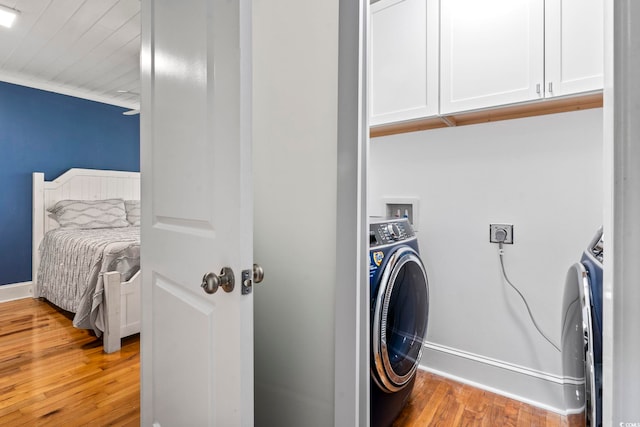 washroom with wood-type flooring, cabinets, and washer / clothes dryer