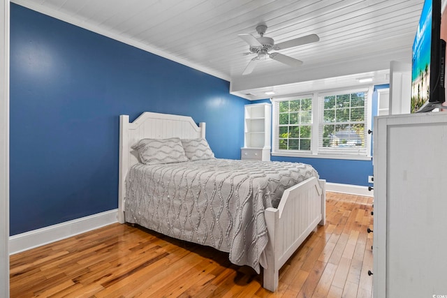 bedroom featuring ornamental molding, wood ceiling, light wood-type flooring, and ceiling fan