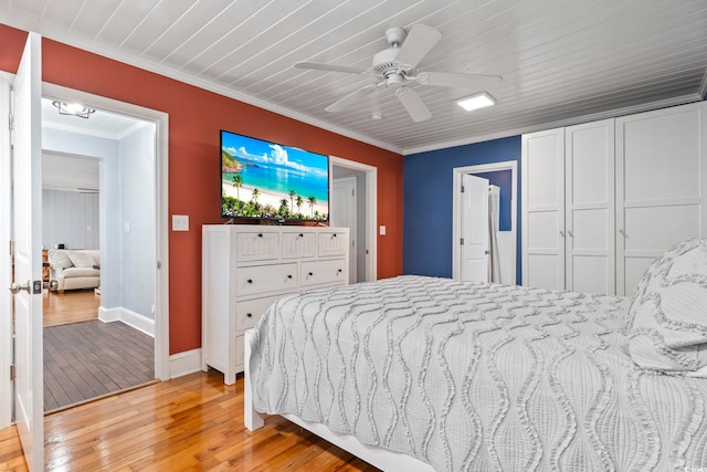 bedroom with a closet, ceiling fan, crown molding, and light wood-type flooring