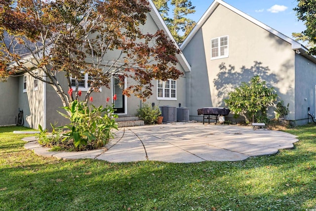 back of house featuring central air condition unit, a patio, and a lawn