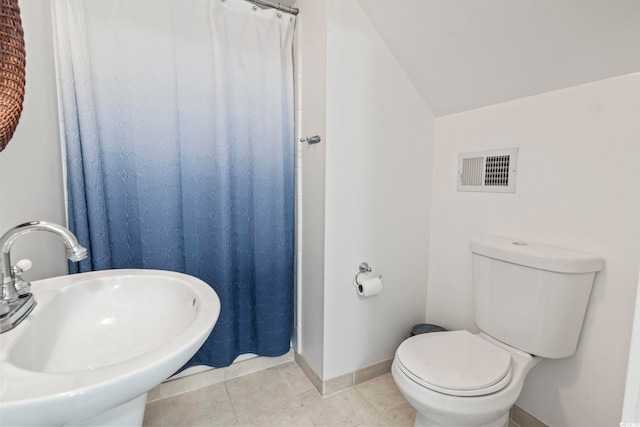 bathroom with tile patterned floors, lofted ceiling, toilet, sink, and curtained shower