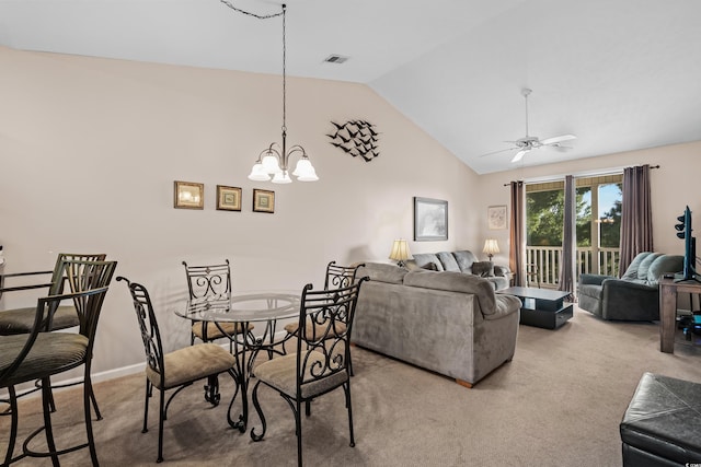 carpeted dining space with high vaulted ceiling and ceiling fan with notable chandelier