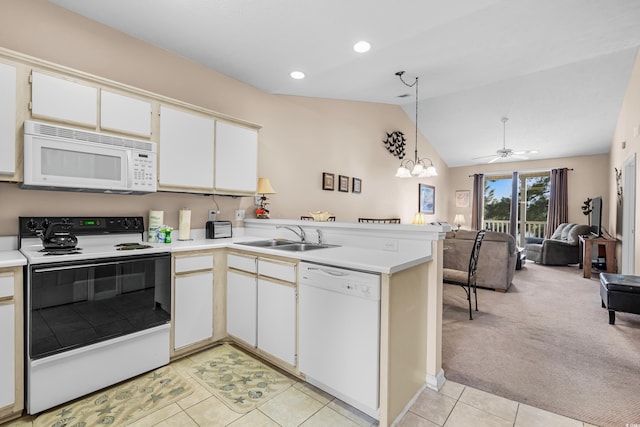 kitchen featuring white appliances, sink, hanging light fixtures, vaulted ceiling, and light colored carpet