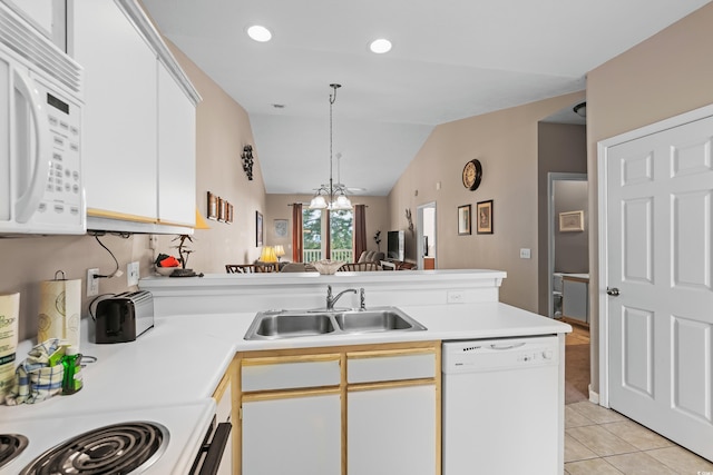 kitchen featuring white appliances, sink, kitchen peninsula, white cabinetry, and vaulted ceiling