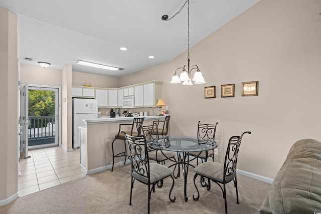 carpeted dining area featuring a chandelier