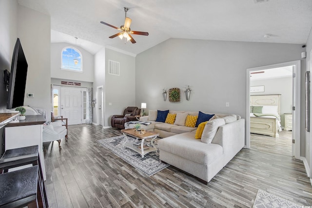 living room with hardwood / wood-style floors, high vaulted ceiling, and ceiling fan