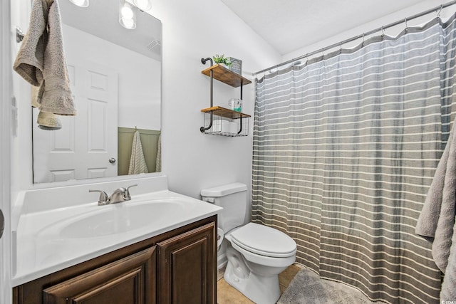 bathroom with toilet, vanity, and tile patterned flooring