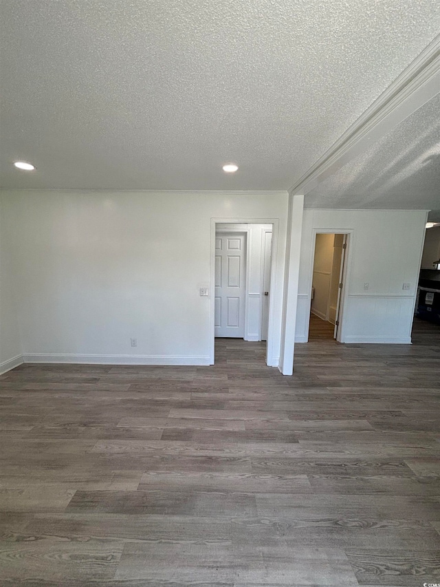 empty room with dark wood-type flooring and a textured ceiling