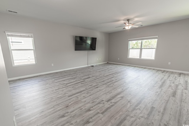 spare room featuring light wood-style floors, baseboards, visible vents, and ceiling fan