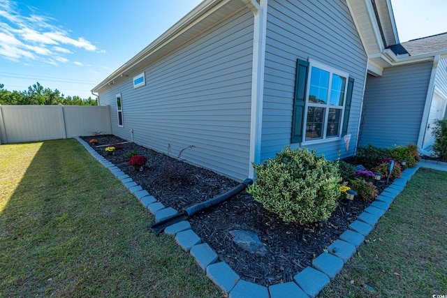 view of side of property featuring a yard and fence