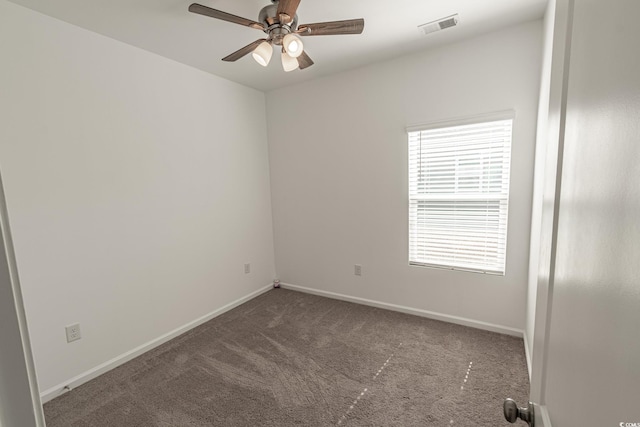 unfurnished room featuring baseboards, visible vents, dark colored carpet, and a ceiling fan