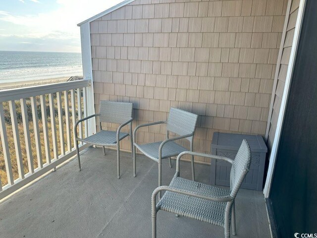 balcony with a water view and a beach view