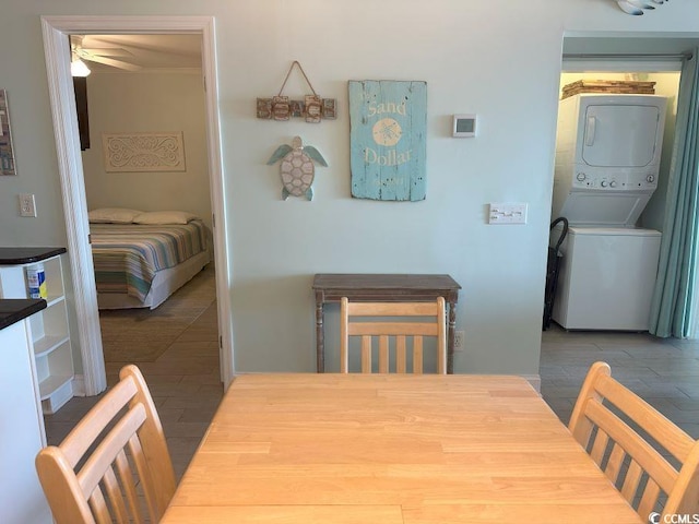 dining area with ceiling fan and stacked washer / dryer