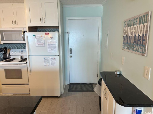 kitchen featuring white cabinets, white appliances, light hardwood / wood-style floors, and ornamental molding