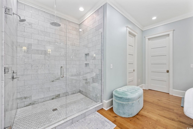 bathroom featuring an enclosed shower, hardwood / wood-style floors, and ornamental molding