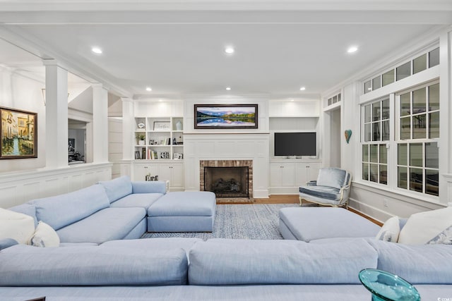 living room featuring built in features, hardwood / wood-style floors, and ornamental molding