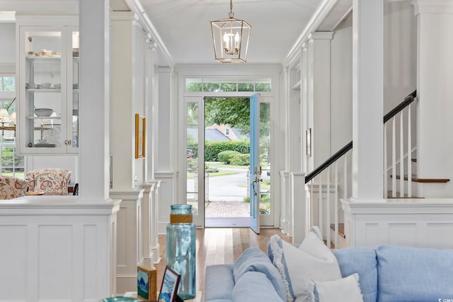 entryway with light hardwood / wood-style flooring, a notable chandelier, and plenty of natural light