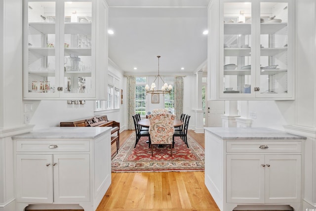 dining space with light hardwood / wood-style floors, a chandelier, and crown molding