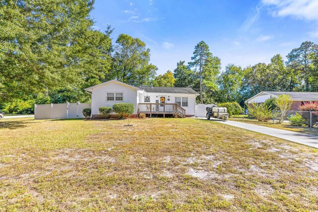 view of front of home with a wooden deck and a front yard