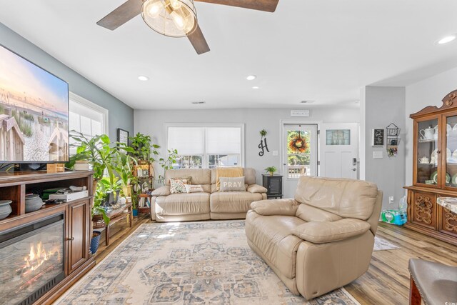 living room with light hardwood / wood-style flooring and ceiling fan