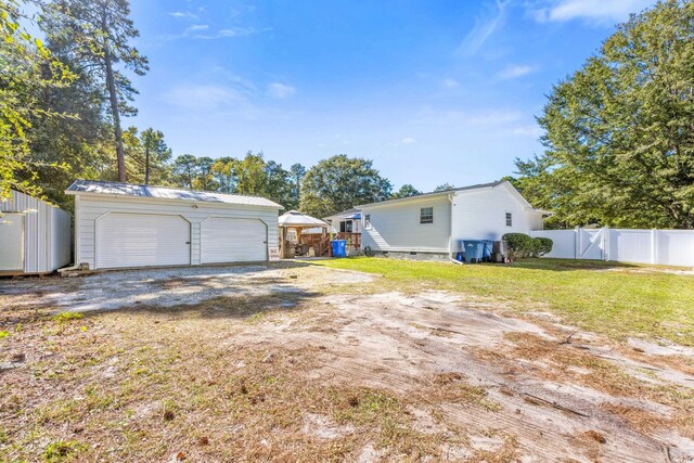 exterior space with a yard, a garage, and an outdoor structure