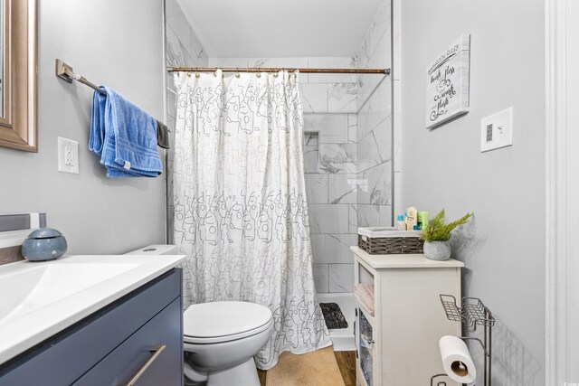 bathroom featuring vanity, toilet, and curtained shower