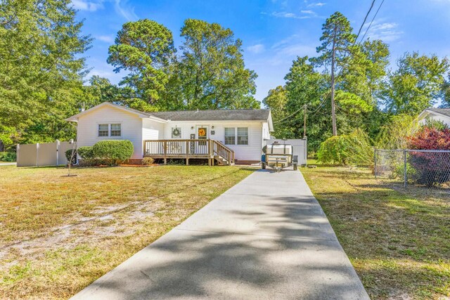 view of front facade featuring a deck and a front lawn