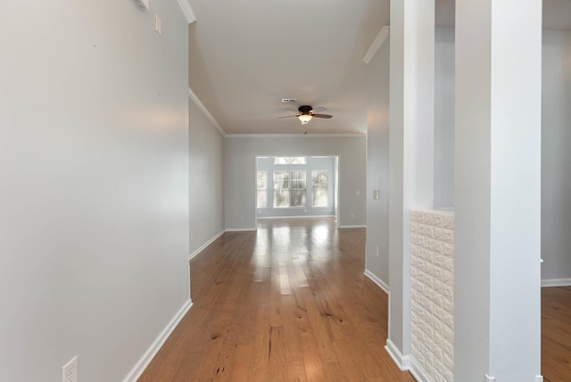 corridor with hardwood / wood-style flooring and crown molding