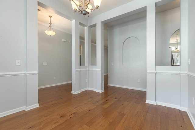 unfurnished dining area with hardwood / wood-style flooring, a chandelier, and crown molding