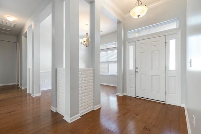 foyer entrance featuring a chandelier, crown molding, and dark hardwood / wood-style flooring