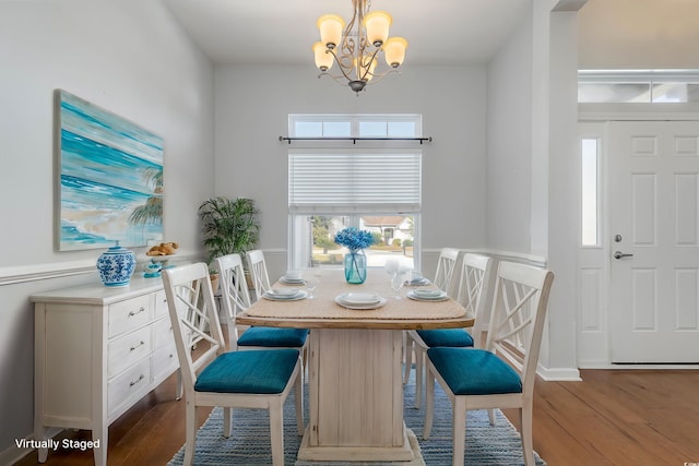 dining room featuring a chandelier, a wainscoted wall, and wood finished floors