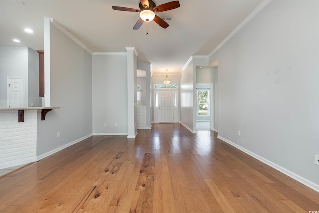 unfurnished living room featuring baseboards, light wood finished floors, ceiling fan, visible vents, and crown molding