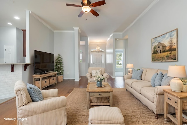 living area featuring baseboards, crown molding, ceiling fan with notable chandelier, and wood finished floors