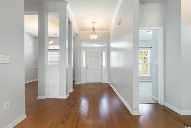 entrance foyer with baseboards, crown molding, and wood-type flooring