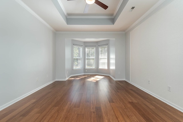 unfurnished room featuring dark hardwood / wood-style floors, crown molding, a tray ceiling, and ceiling fan