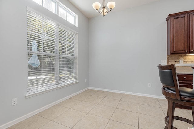 unfurnished office with an inviting chandelier, baseboards, and light tile patterned floors