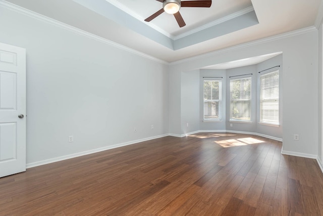 unfurnished room with dark wood-type flooring, ceiling fan, crown molding, and a tray ceiling