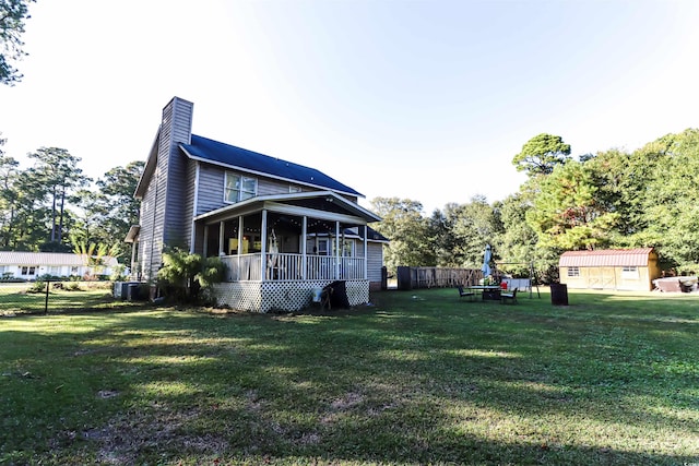 view of property exterior featuring a lawn, central AC, and a shed