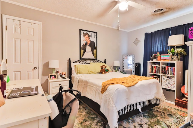 bedroom with ceiling fan, ornamental molding, and a textured ceiling