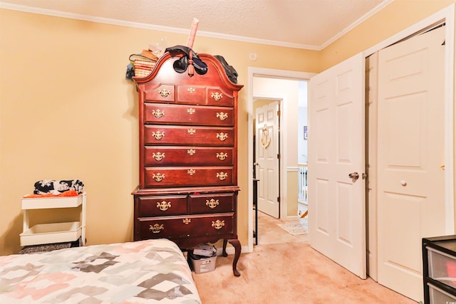 carpeted bedroom with a textured ceiling, a closet, and crown molding